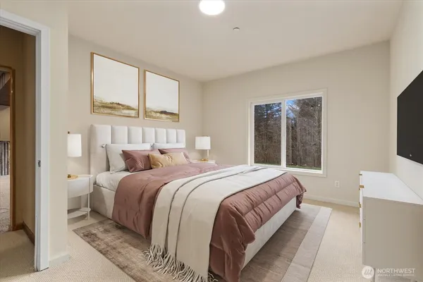 a bedroom with a large bed and a flat tv screen on dresser