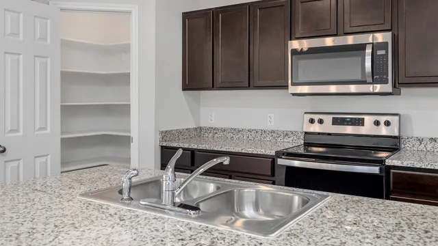 a kitchen with a sink a counter space and stainless steel appliances