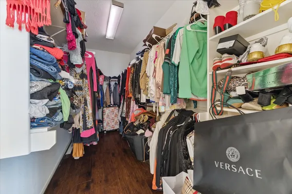 a view of walk in closet with clothes and shoes