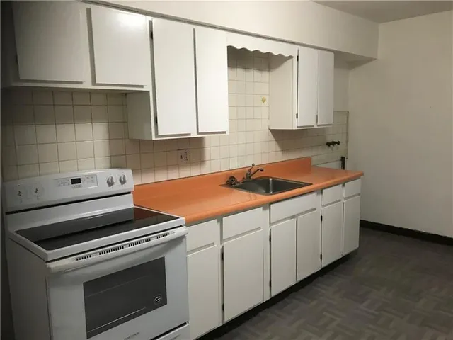 a kitchen with granite countertop white cabinets and white appliances
