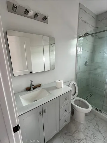 a bathroom with a double vanity sink toilet and shower