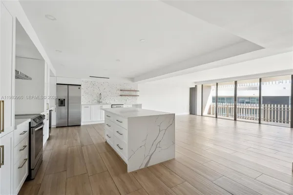 a kitchen with wooden floors and white cabinets