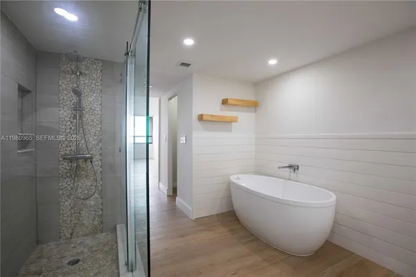 a spacious bathroom with a bathtub and shower