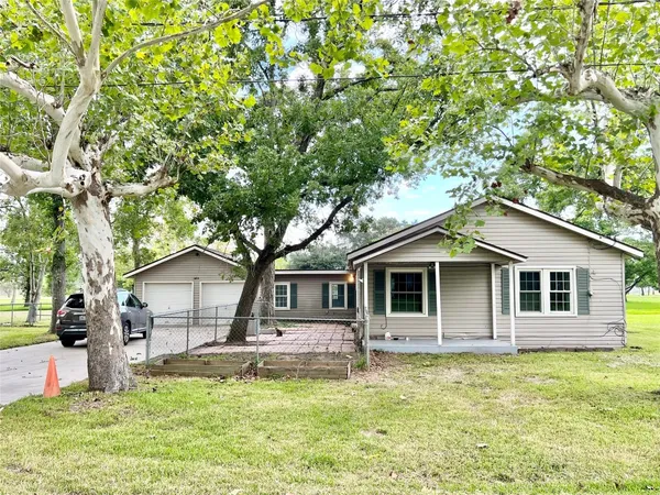 a front view of a house with a garden and tree