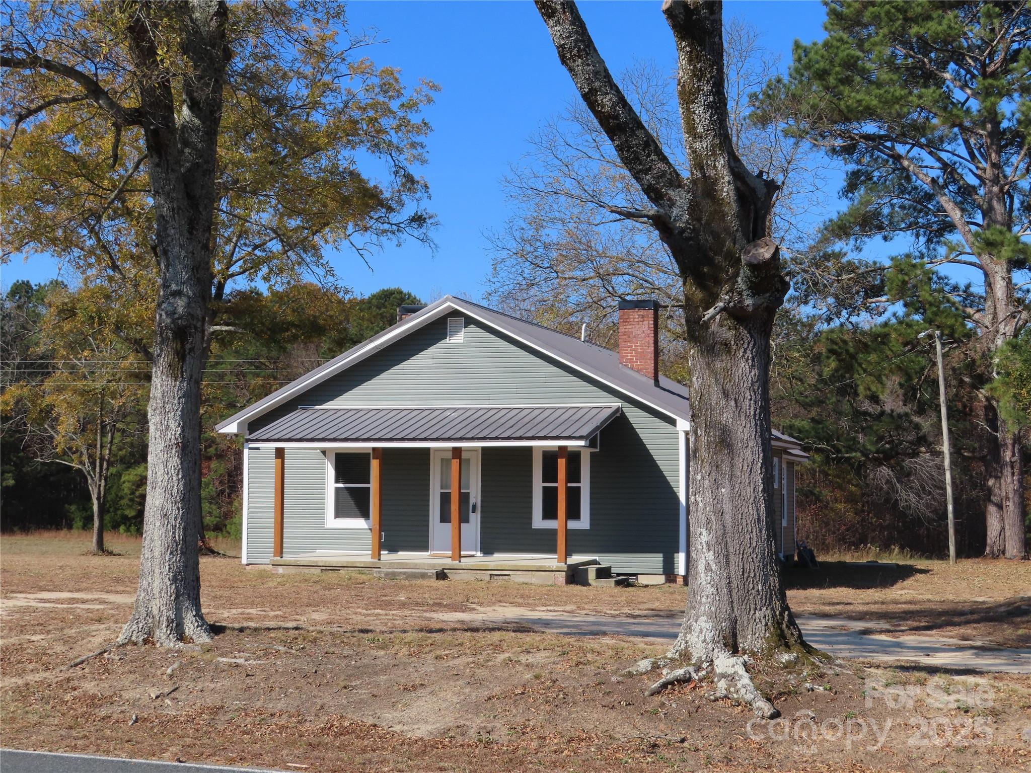 a front view of a house with a garden and trees