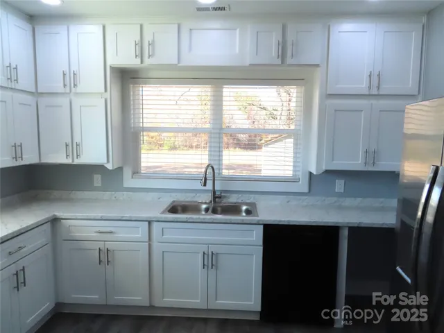 a kitchen with cabinets appliances a sink and a window