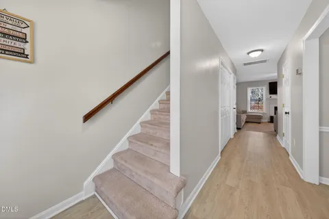 a view of a hallway with wooden floor and staircase