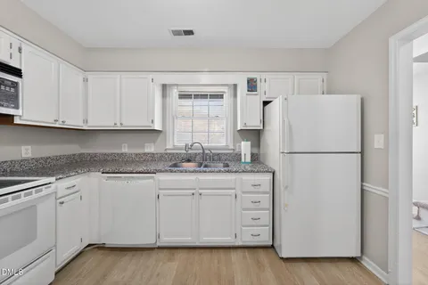 a kitchen with appliances a sink and cabinets