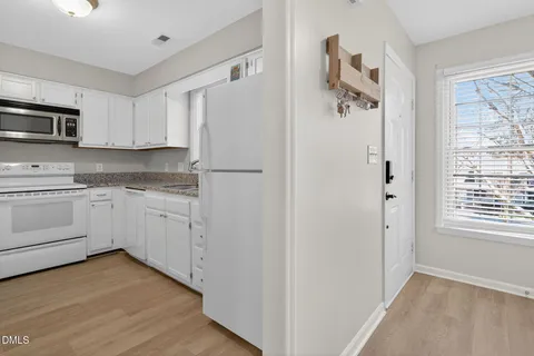 a kitchen with white cabinets and white appliances