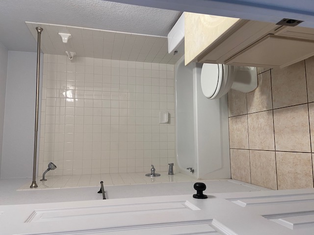 3700 Dustin Court, Unit B Killeen, TX 76549 - Photo 11 of 22 Bathroom featuring vanity, bathing tub / shower combination, a textured wall, and light tile patterned floors