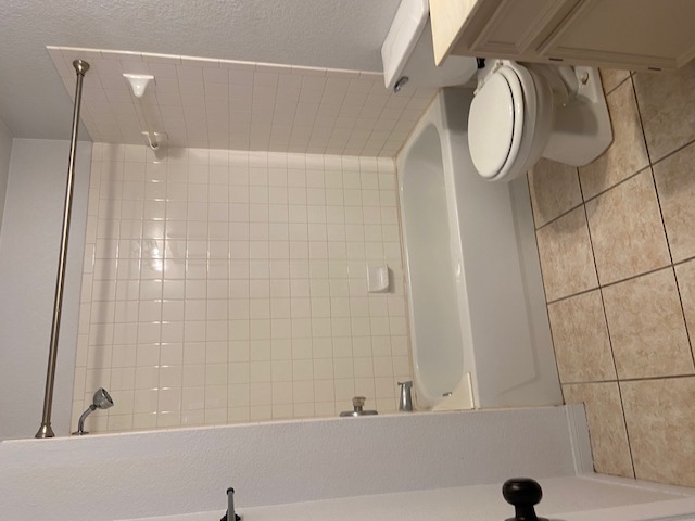 3700 Dustin Court, Unit B Killeen, TX 76549 - Photo 20 of 22 Full bath featuring a textured wall, shower combination, vanity, and light tile patterned floors