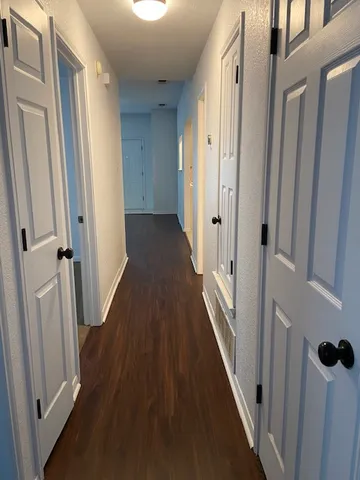 a view of a hallway with wooden floor and staircase