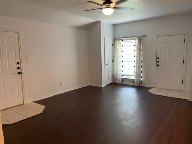 an empty room with wooden floor and door