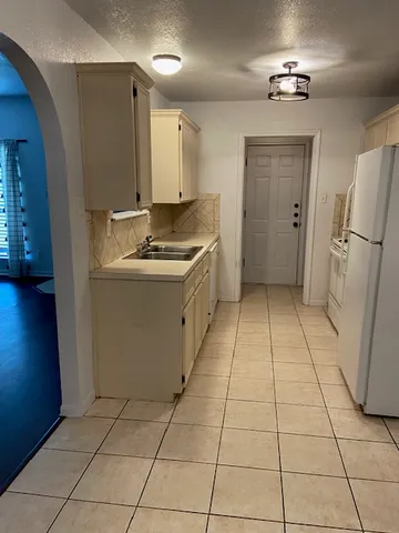 a kitchen with a sink a refrigerator and a stove