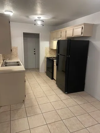 a kitchen with a refrigerator a stove top oven and cabinets
