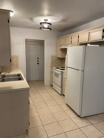 a kitchen with cabinets a refrigerator and a stove