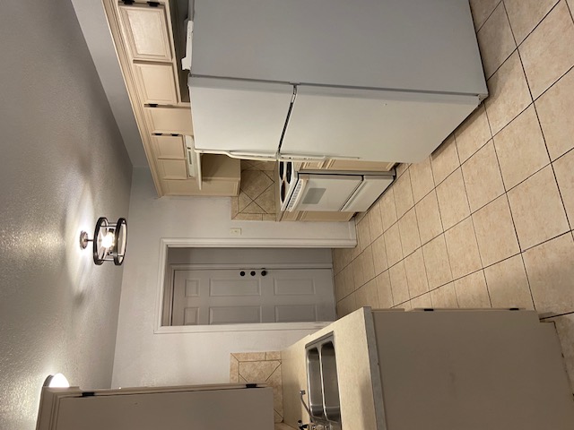 3700 Dustin Court, Unit B Killeen, TX 76549 - Photo 5 of 22 Kitchen featuring white appliances, a textured ceiling, light countertops, light tile patterned floors, and under cabinet range hood