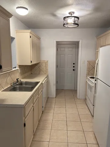 a kitchen with a sink and a refrigerator