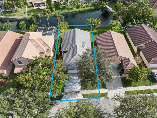 an aerial view of a house with a garden and a lake view