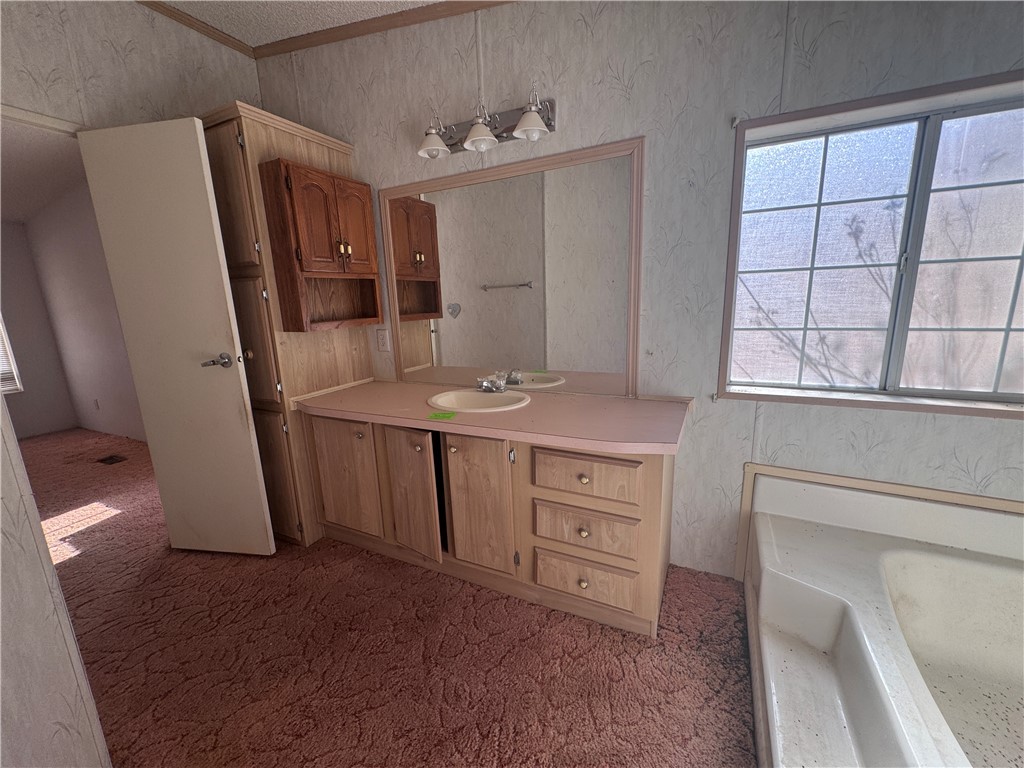 3053 McConnico Road Golden Valley, AZ 86413 - Photo 17 of 18 Full bathroom with vanity, a bathtub, wallpapered walls, and ornamental molding