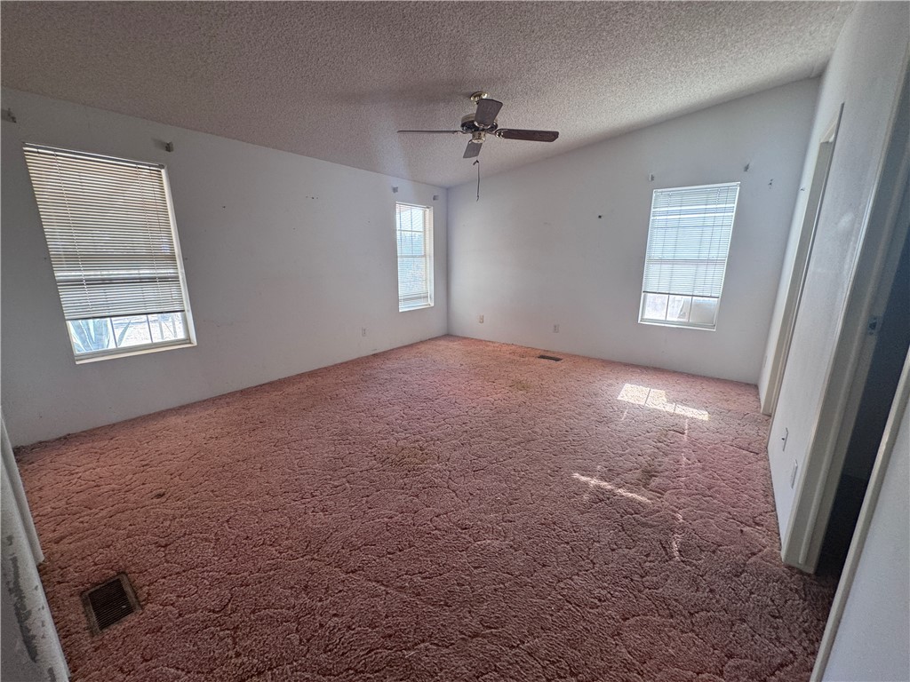 3053 McConnico Road Golden Valley, AZ 86413 - Photo 8 of 18 Carpeted empty room featuring a textured ceiling and ceiling fan