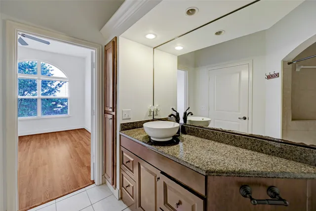 a bathroom with a granite countertop sink and a mirror