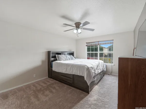 a bed sitting in a spacious bedroom next to a window