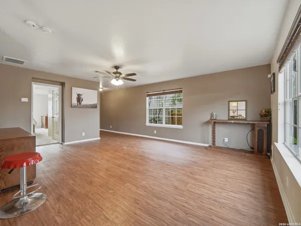 a view of an empty room with a window and wooden floor