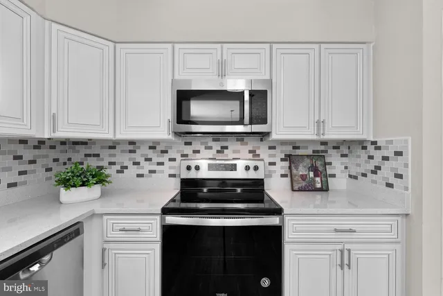 a kitchen with cabinets a stove and microwave