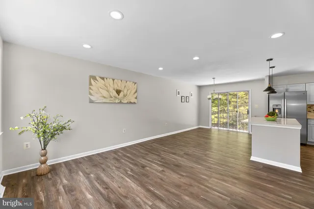 a view of empty room with wooden floor and window