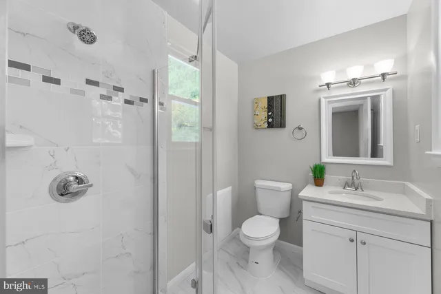 a bathroom with a toilet a sink a mirror and a shower