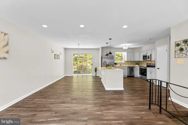 a view of kitchen with kitchen island microwave and cabinets