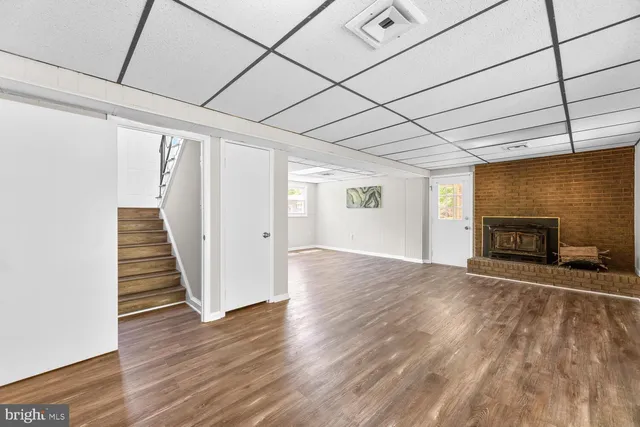 an empty room with wooden floor and fireplace
