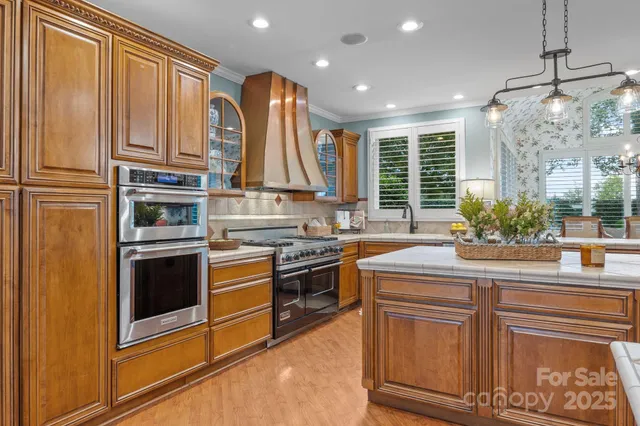 a kitchen with kitchen island granite countertop a stove and a sink