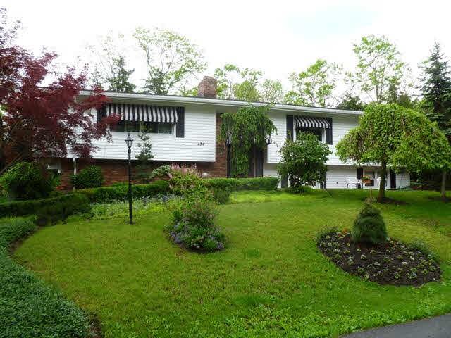 a view of a house with a yard and sitting area
