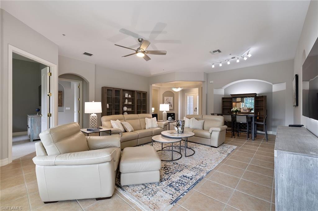 17066 Porta Vecchio Way, Unit 101 Naples, FL 34110 - Photo 12 of 32 a living room with furniture and a dining table with kitchen view