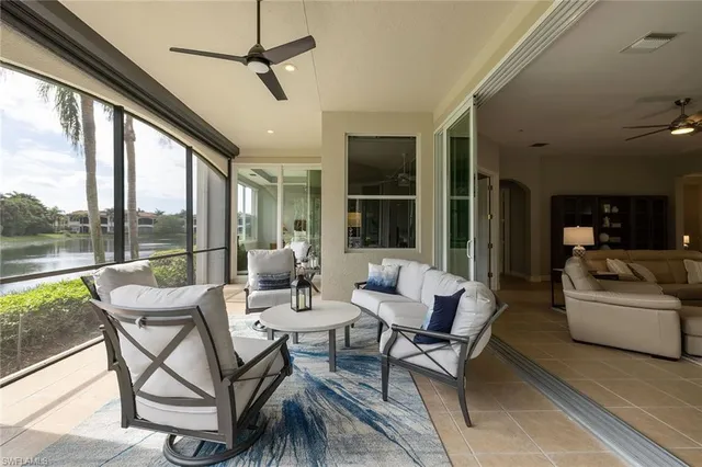a living room with patio furniture and a floor to ceiling window