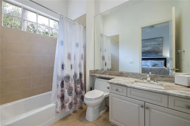 a bathroom with a granite countertop sink toilet a large mirror a bathtub and shower
