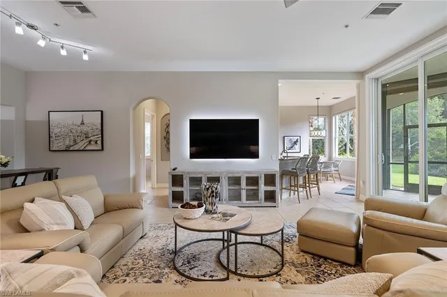 a living room with furniture a flat screen tv and a large window