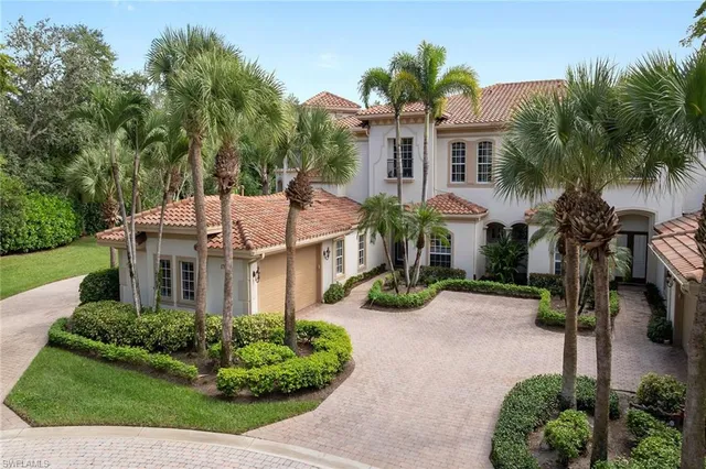 a front view of a house with a yard and potted plants
