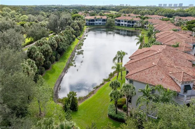 an aerial view of residential houses with outdoor space and lake view