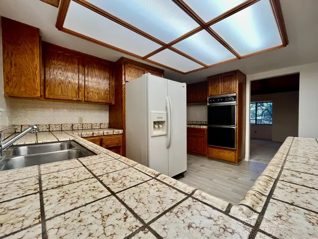 a kitchen with granite countertop a refrigerator and a sink