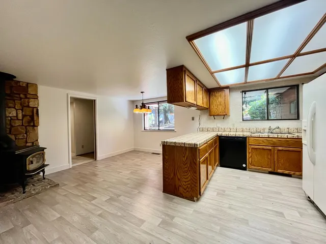 a large kitchen with stainless steel appliances granite countertop a stove a sink and a refrigerator