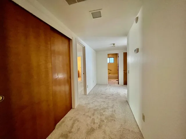 a view of a hallway with wooden shelves