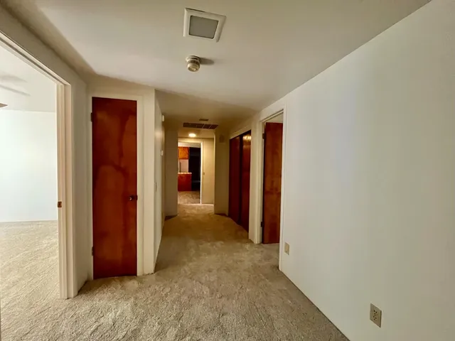 a view of hallway with closet and wooden floor