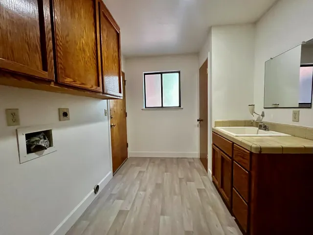 a kitchen with a sink and wooden floor