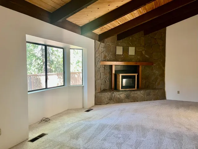 a view of an empty room with a fireplace and a window