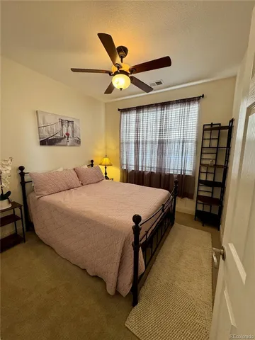 a bed room with a bed and a ceiling fan