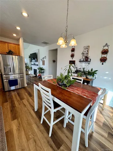 a dining room filled chandelier and wooden furniture