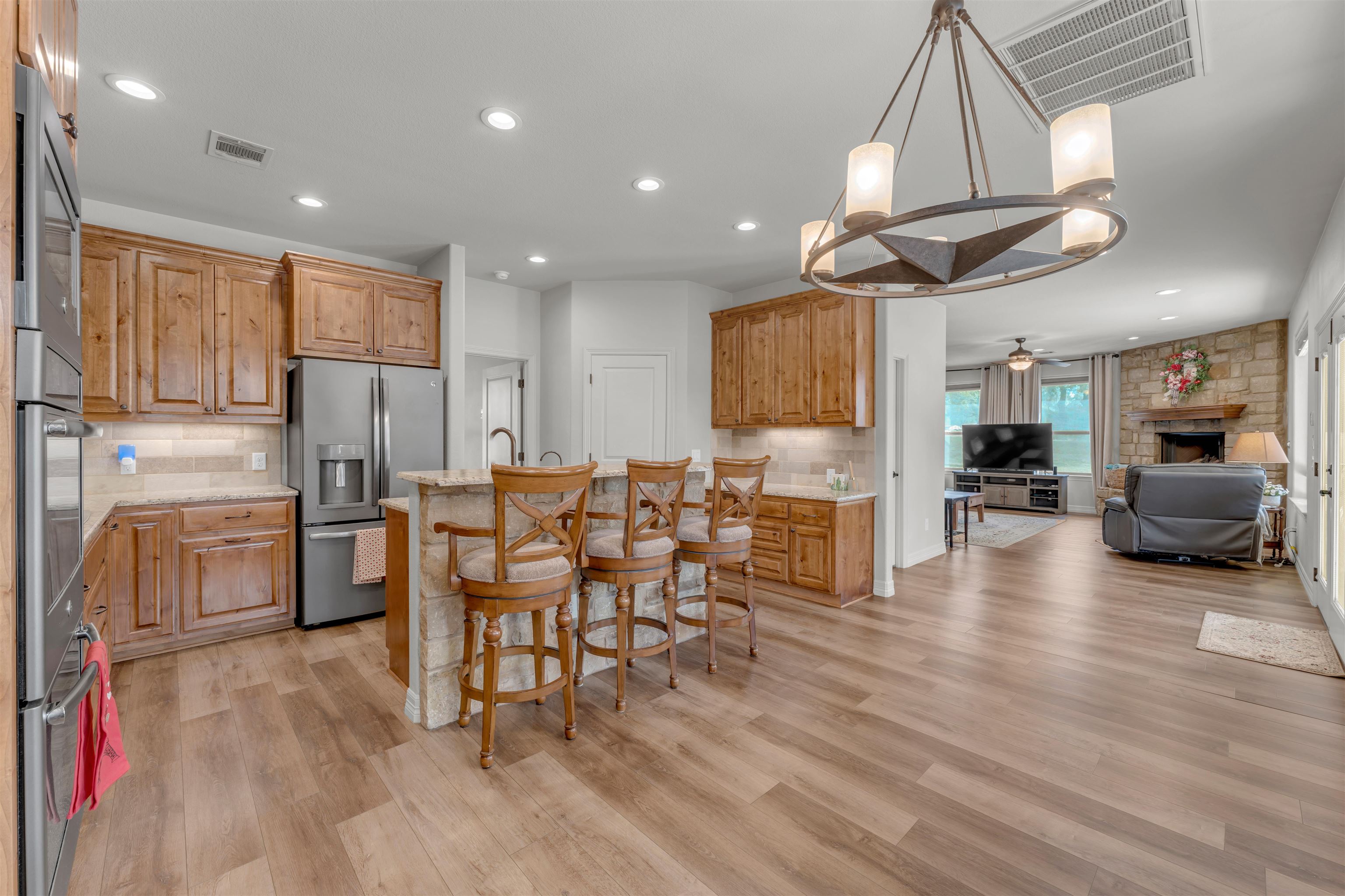 227 Watkins Point Kingsland, TX 78639 - Photo 9 of 30 a view of kitchen with refrigerator microwave and wooden floor
